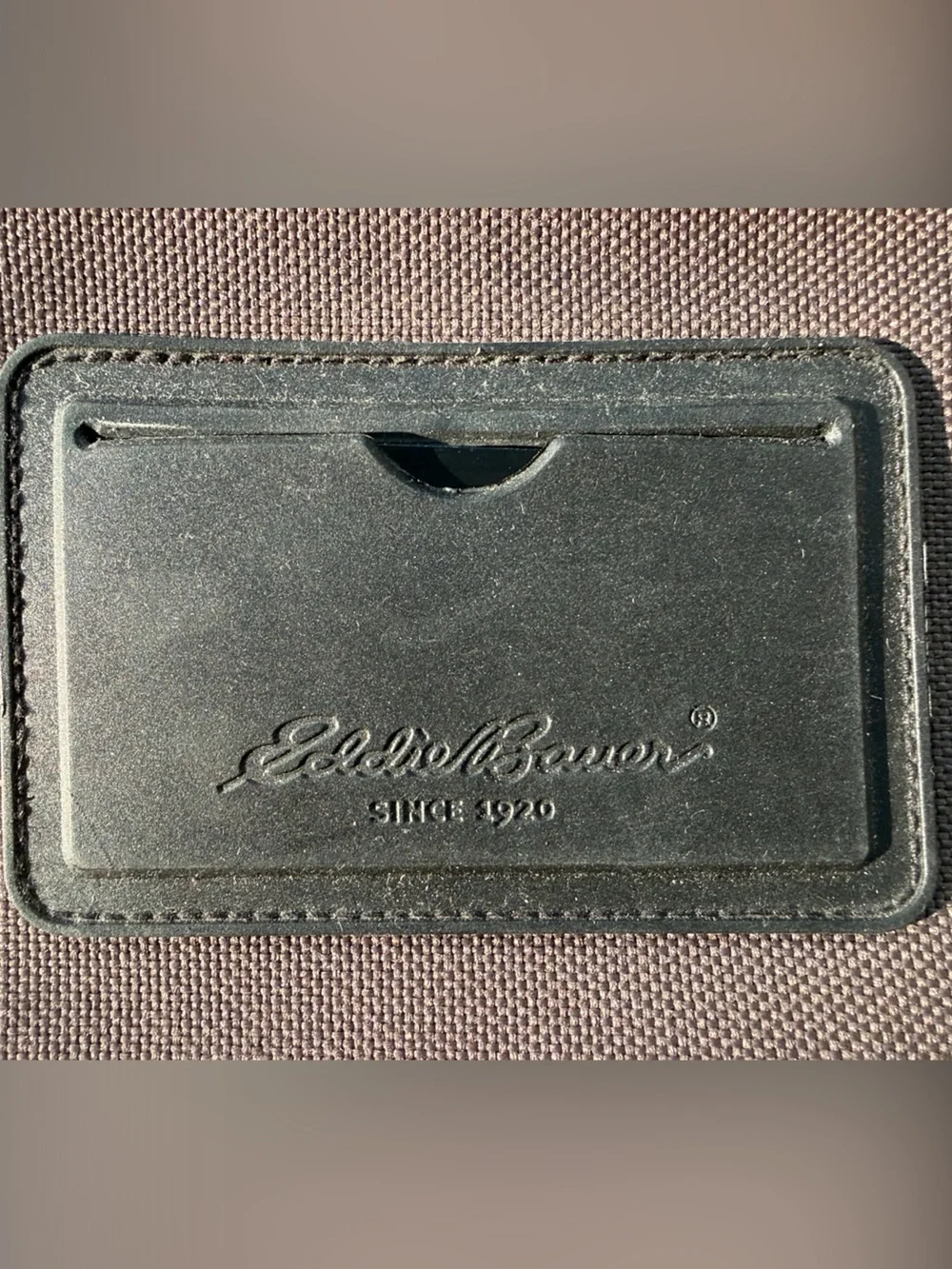 Eddie Bauer army green carry-on bag with black hand straps and shoulder strap